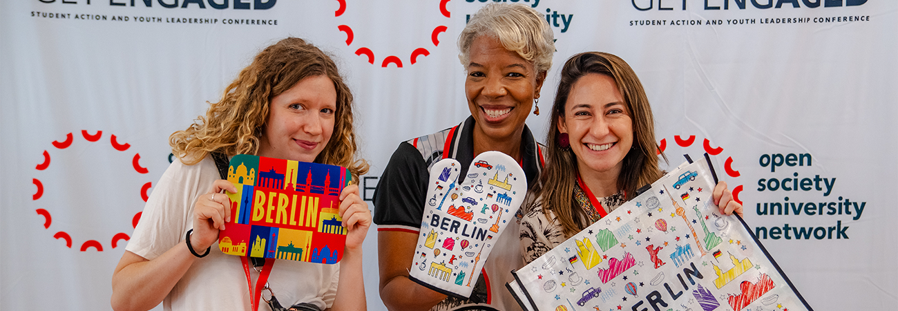Three faculty members posing with Berlin merch at the Get Engaged Conference