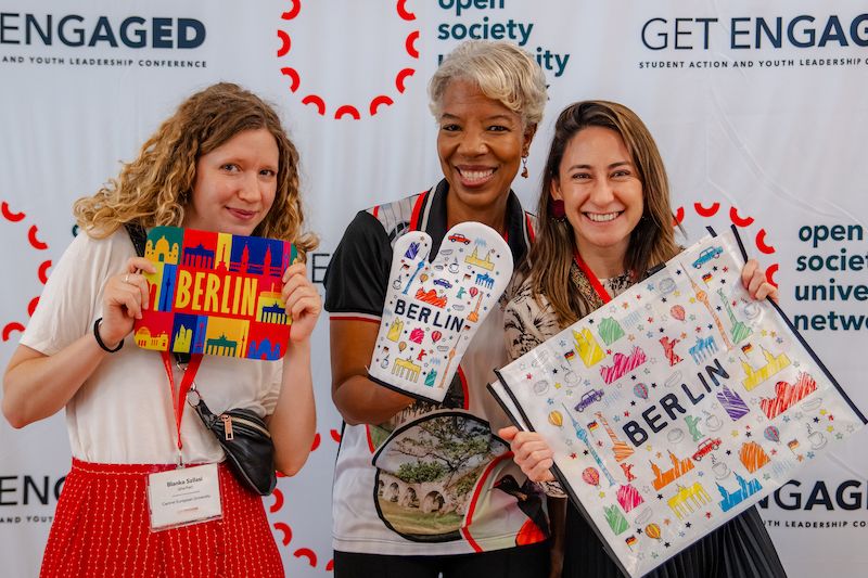 Three faculty members posing with Berlin merch at the Get Engaged Conference