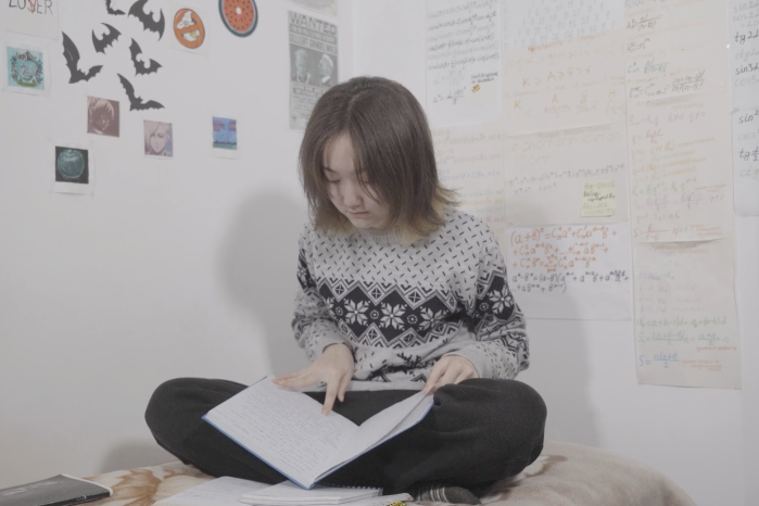 Kayirkul studying on her bed