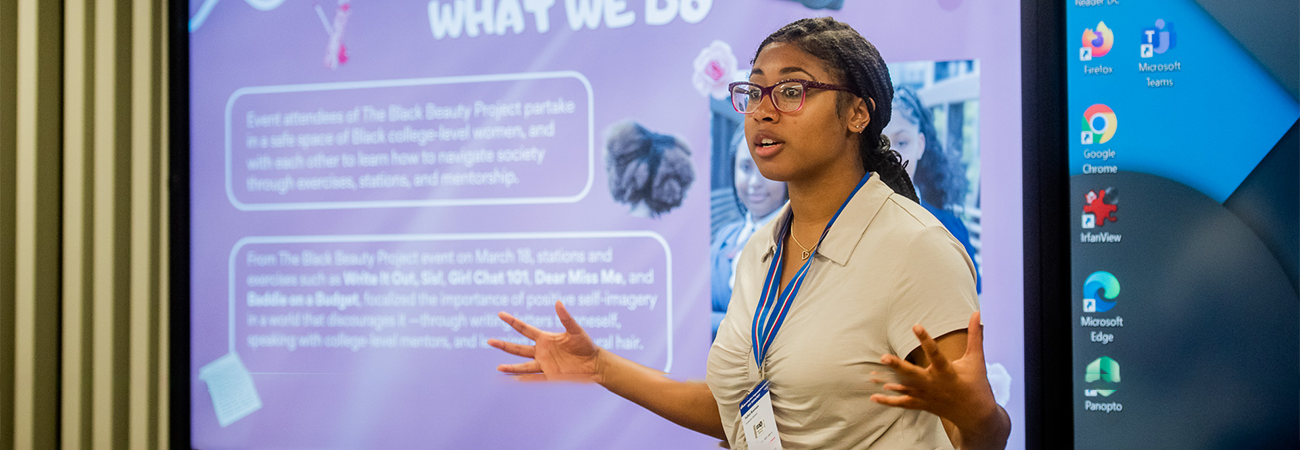 Student presenting in front of her presentation