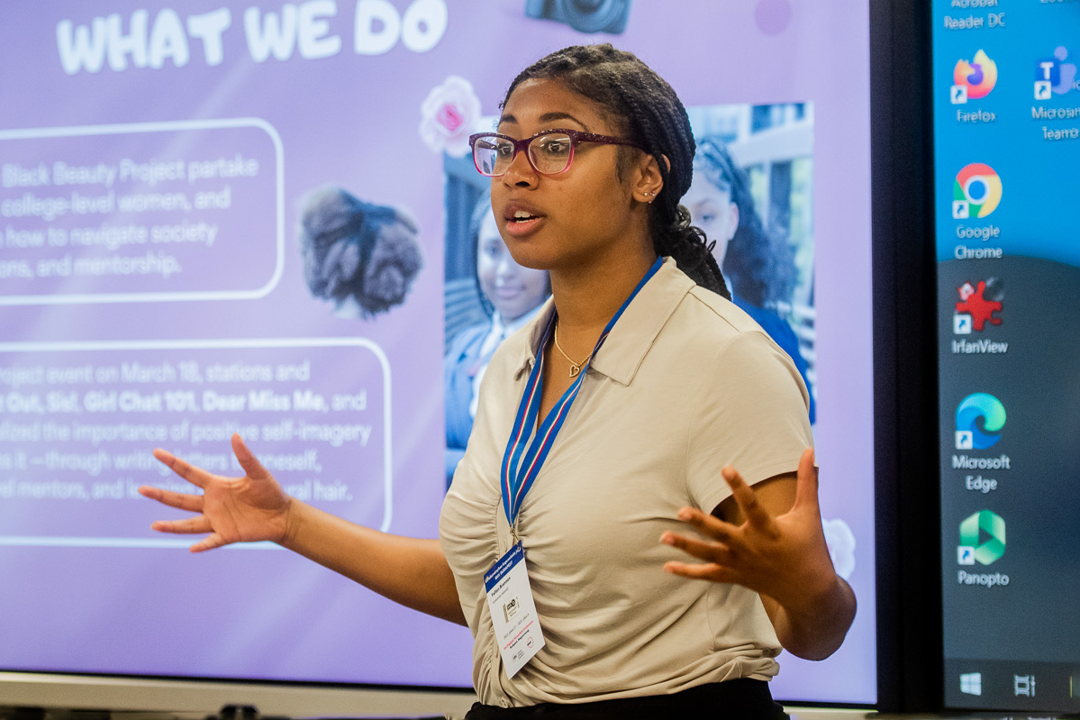 Student presenting in front of slideshow