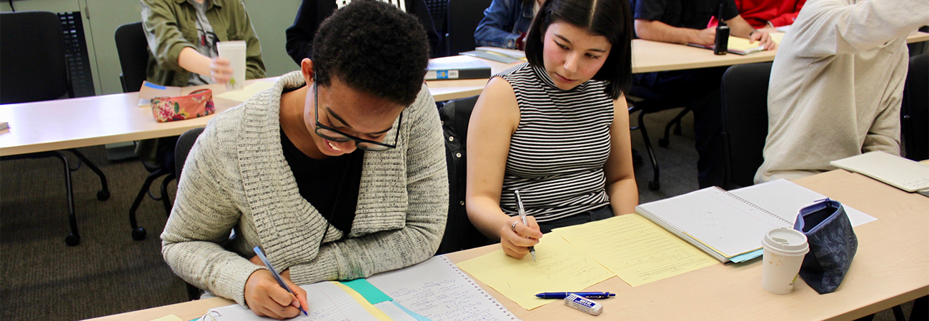 Two Bard students in class writing