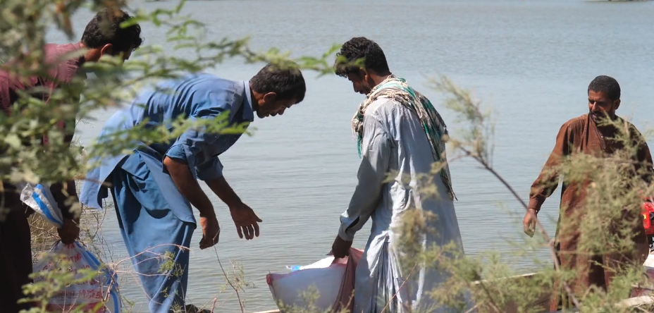 Four men loading cargo on a boat in Pakistan