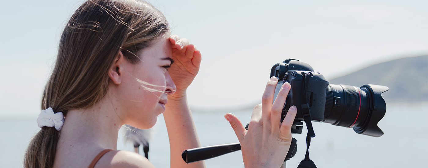 Young woman looking into a camera on a tripod