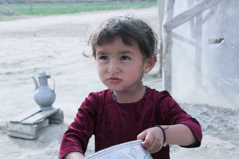 Lyuli girl holding a piece of traditional headwear